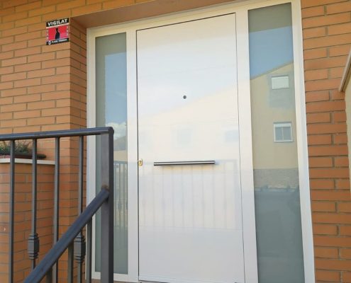 Puerta de entrada de aluminio de diseño moderno instalada en vivienda por SolGlass